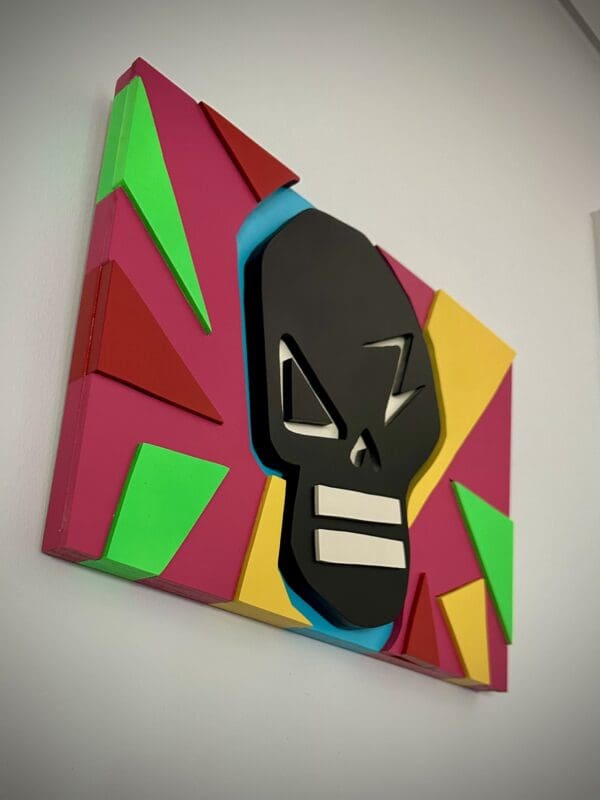 A colorful painting of a mask on the wall.