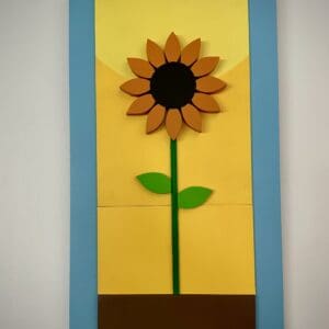 A sunflower made out of wood blocks and paper.